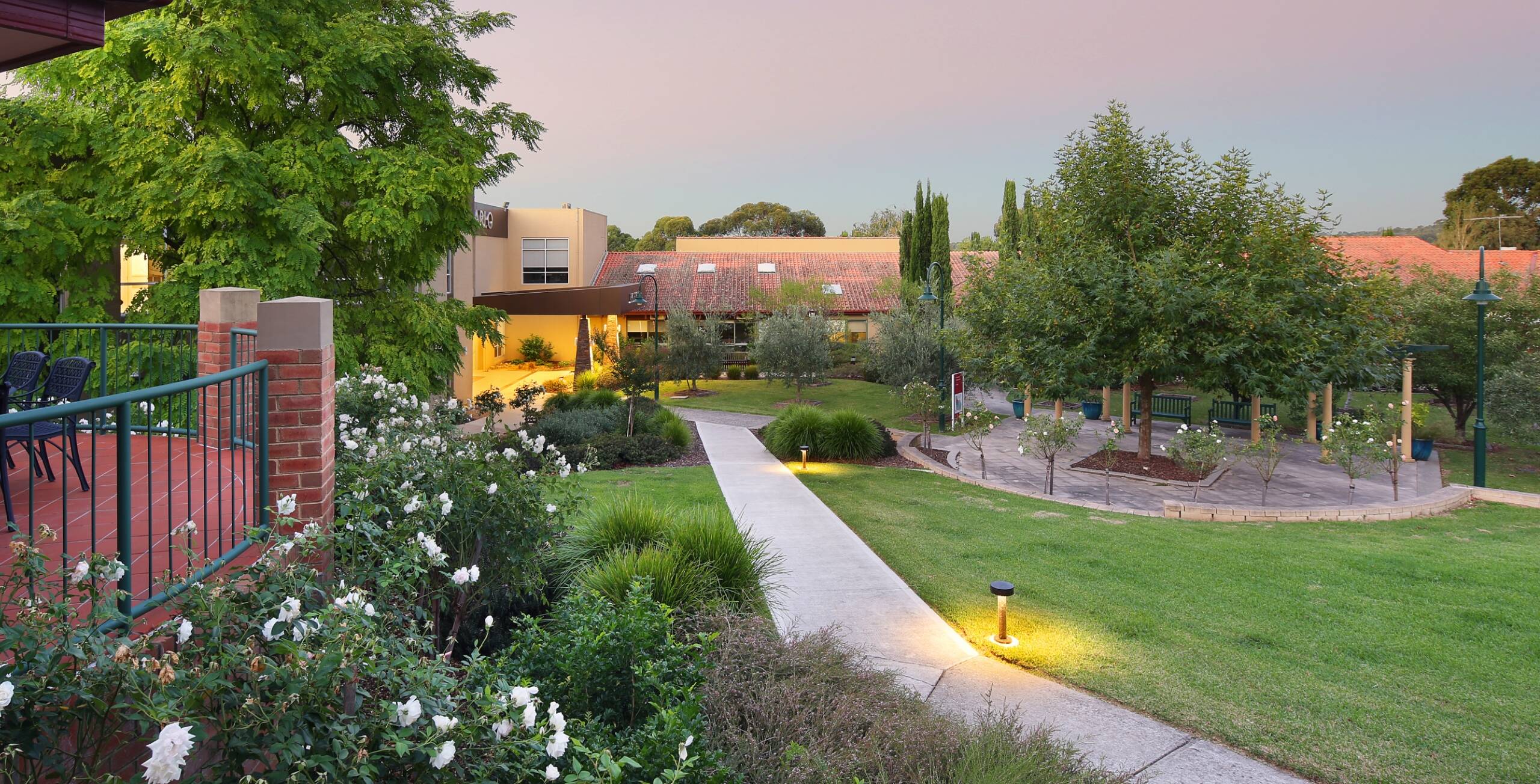 A courtyard at San Carlo with gardens, grassed areas, and walking paths.