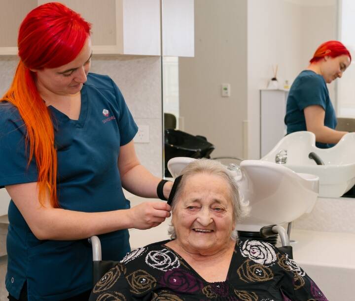 A resident having their hair styled in a salon.