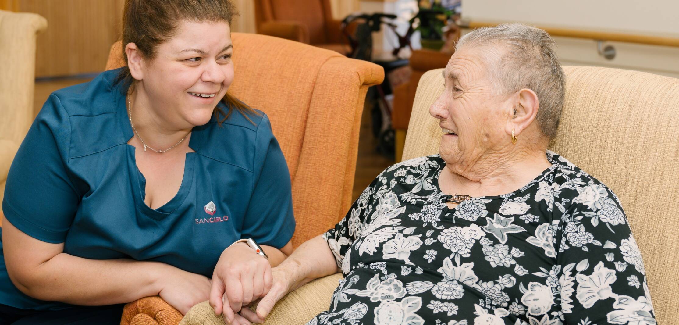 A resident speaking and laughing with a member of the San Carlo staff.